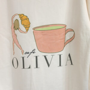 Beige hoodie featuring a pink teacup illustration with text reading OLIVIA beneath it.