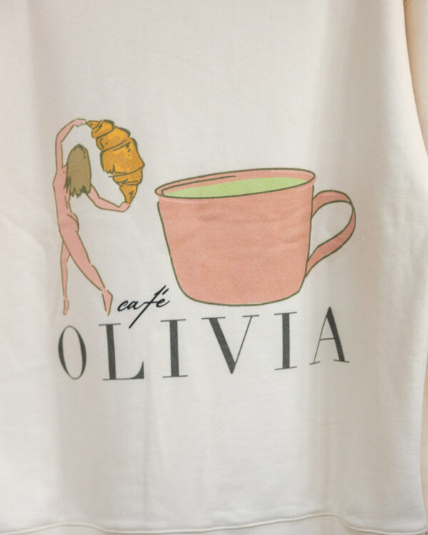 Beige hoodie featuring a pink teacup illustration with text reading OLIVIA beneath it.